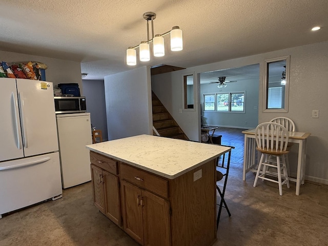 2705 Pine St, Rock Falls, IL 61071 - kitchen with freestanding refrigerator, a textured ceiling, stainless steel microwave, a kitchen island, and hanging light fixtures