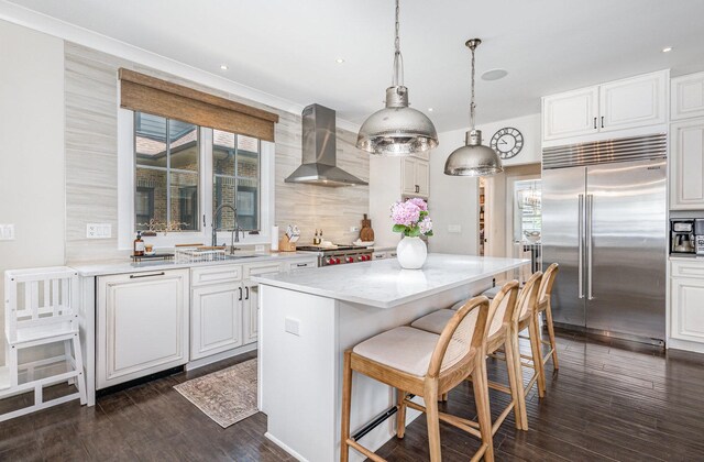 26 S Chestnut Ave, Arlington Heights, IL 60005 - kitchen with built in fridge, wall chimney range hood, a kitchen bar, dark wood-style flooring, and decorative backsplash