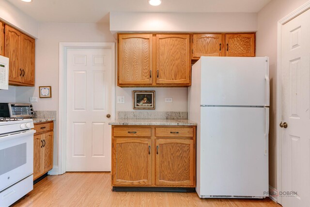 211 Winding Oak Ln, Buffalo Grove, IL 60089 - kitchen with white appliances, light wood-style flooring, recessed lighting, light stone counters, and brown cabinetry