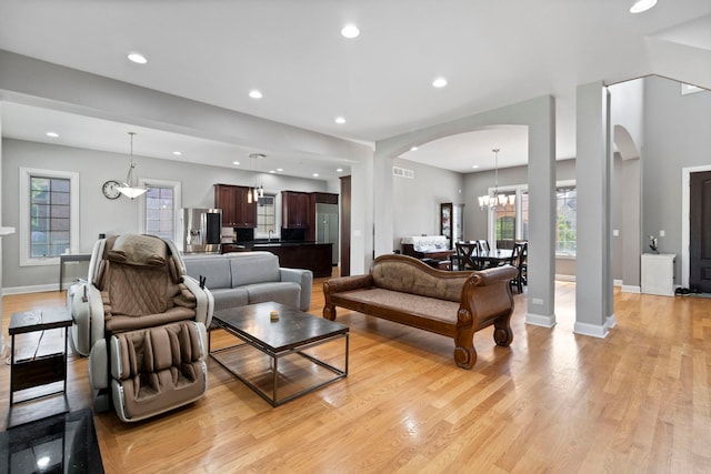 4146 Cardinal Ct, Northbrook, IL 60062 - living room with arched walkways, light wood-style floors, a chandelier, and recessed lighting