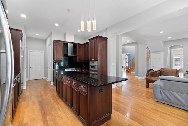 4146 Cardinal Ct, Northbrook, IL 60062 - kitchen with arched walkways, wall chimney exhaust hood, oven, open floor plan, and light wood-style flooring