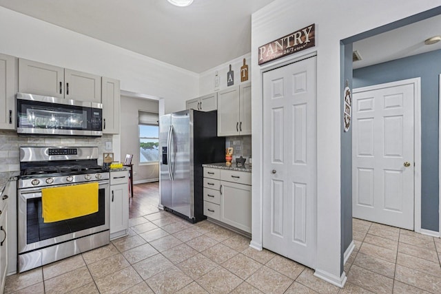 1021 Horizon Rdg, Lake In The Hills, IL 60156 - kitchen featuring stainless steel appliances, decorative backsplash, light stone counters, and light tile patterned flooring