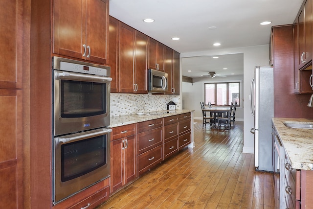 18W761 83rd St, Downers Grove, IL 60516 - kitchen with appliances with stainless steel finishes, ceiling fan, backsplash, light wood-style floors, and light stone countertops