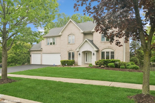 1580 W N St, Palatine, IL 60067 - view of front of house with asphalt driveway, an attached garage, a front lawn, roof with shingles, and brick siding
