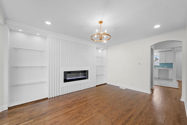 8416 S Bennett Ave, Chicago, IL 60617 - unfurnished living room featuring ornamental molding, wood finished floors, arched walkways, built in features, and a chandelier