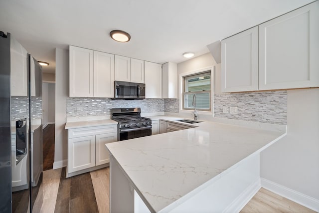4850 N Clifton Ave, Norridge, IL 60706 - kitchen featuring appliances with stainless steel finishes, light wood-style flooring, white cabinets, and light stone counters