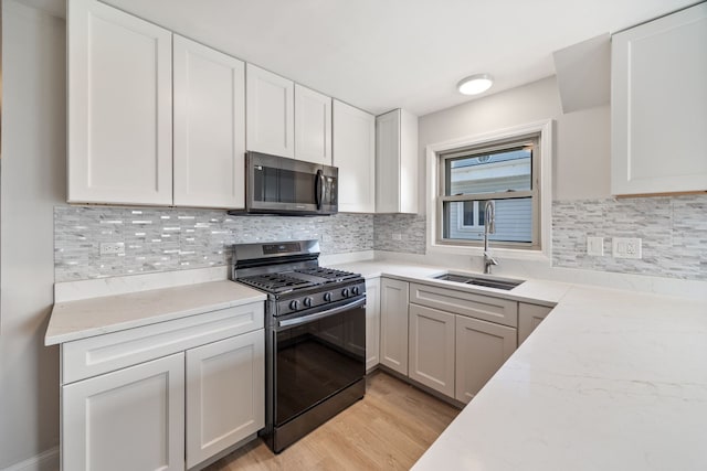 4850 N Clifton Ave, Norridge, IL 60706 - kitchen featuring stainless steel appliances, white cabinets, light wood-style floors, light stone countertops, and backsplash