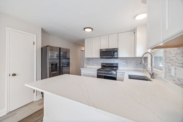 4850 N Clifton Ave, Norridge, IL 60706 - kitchen featuring stainless steel appliances, tasteful backsplash, light stone counters, a peninsula, and white cabinets