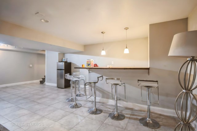 837 Hamlin Ave, Flossmoor, IL 60422 - kitchen featuring freestanding refrigerator, tile patterned flooring, a kitchen bar, and pendant lighting