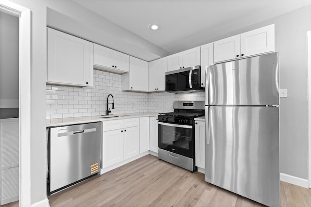 4025 Williams St, Downers Grove, IL 60515 - kitchen with appliances with stainless steel finishes, light countertops, white cabinetry, decorative backsplash, and light wood finished floors