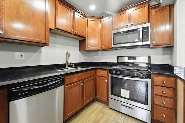 2501 W Touhy Ave Unit 105, Chicago, IL 60645 - kitchen with appliances with stainless steel finishes, light wood-style flooring, brown cabinets, dark stone countertops, and recessed lighting