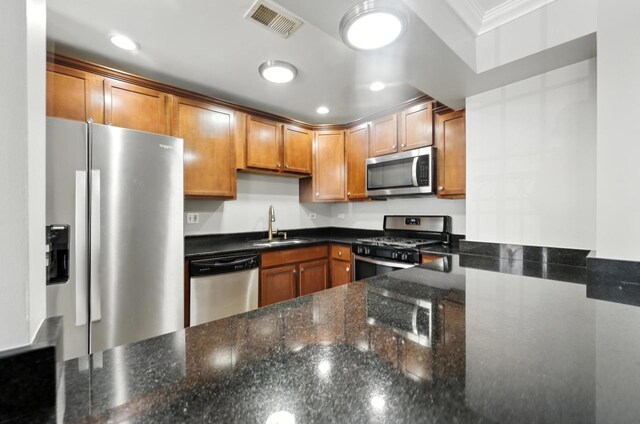 2501 W Touhy Ave Unit 105, Chicago, IL 60645 - kitchen with stainless steel appliances, dark stone countertops, crown molding, brown cabinets, and recessed lighting