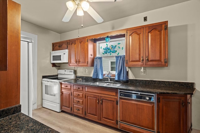6510 Sinclair Ave, Berwyn, IL 60402 - kitchen featuring white appliances, light wood-type flooring, brown cabinetry, ceiling fan, and dark stone counters