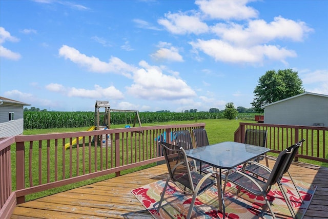 510 W Rhodes St, Thomasboro, IL 61878 - deck featuring outdoor dining space, a playground, and a lawn