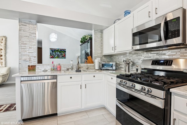 201 Hidden Creek Ln Unit 201, North Aurora, IL 60542 - kitchen with appliances with stainless steel finishes, backsplash, a peninsula, light stone countertops, and white cabinetry