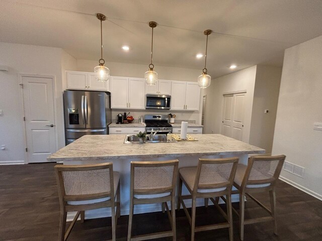 1135 Williamsburg St, Pingree Grove, IL 60140 - kitchen with stainless steel appliances, white cabinetry, a kitchen breakfast bar, a kitchen island with sink, and recessed lighting