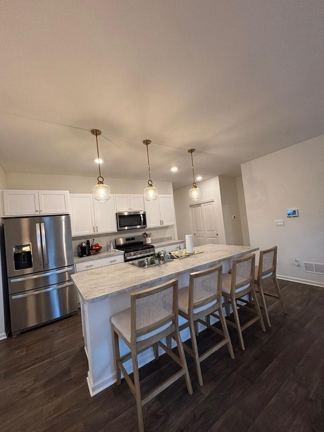 1135 Williamsburg St, Pingree Grove, IL 60140 - kitchen with stainless steel appliances, dark wood-style floors, a center island with sink, white cabinets, and a kitchen bar