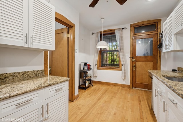 622 W Waveland Ave Unit 2W, Chicago, IL 60613 - kitchen with ceiling fan, white cabinets, light wood-style flooring, light stone countertops, and pendant lighting