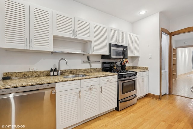 622 W Waveland Ave Unit 2W, Chicago, IL 60613 - kitchen featuring appliances with stainless steel finishes, light wood-style flooring, open shelves, light stone counters, and recessed lighting