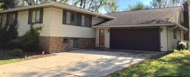 702 Auburn Cir, Schaumburg, IL 60193 - split level home with driveway, a garage, brick siding, and a chimney