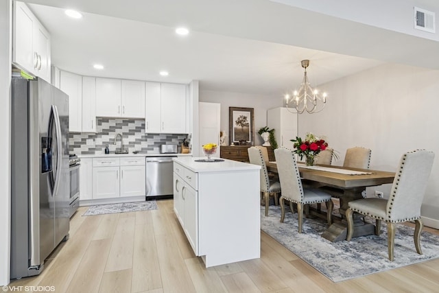 1470 Jefferson St Unit 602, Des Plaines, IL 60016 - kitchen with appliances with stainless steel finishes, light wood-type flooring, white cabinets, a center island, and recessed lighting