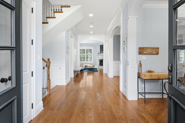 2115 Washington Ave, Wilmette, IL 60091 - entrance foyer with ornate columns, arched walkways, light wood-style flooring, stairway, and crown molding