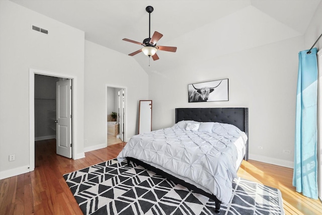 4809 S Wabash Ave Unit 3, Chicago, IL 60615 - bedroom featuring lofted ceiling, wood finished floors, a walk in closet, a ceiling fan, and connected bathroom