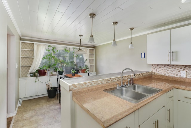 325 W Poplar St S, Heyworth, IL 61745 - kitchen featuring a peninsula, tasteful backsplash, hanging light fixtures, ornamental molding, and light countertops