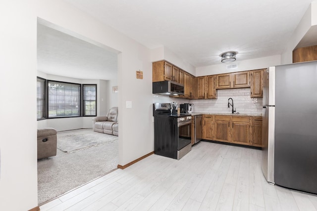 2003 Tracy Dr Unit 1, Bloomington, IL 61704 - kitchen with stainless steel appliances, light wood-type flooring, light countertops, backsplash, and brown cabinets