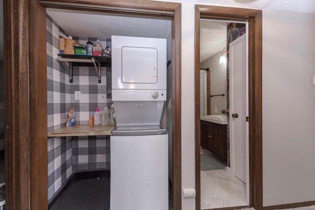 2003 Tracy Dr Unit 1, Bloomington, IL 61704 - washroom featuring estacked washer and dryer and light marble finish floors