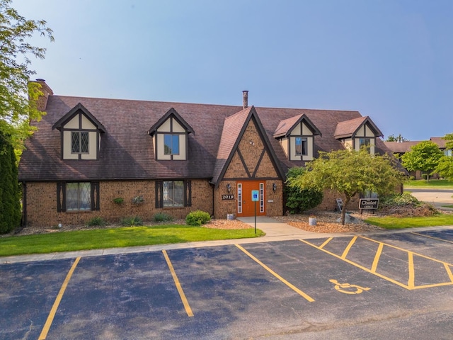 2003 Tracy Dr Unit 1, Bloomington, IL 61704 - view of front facade with uncovered parking, brick siding, and a chimney