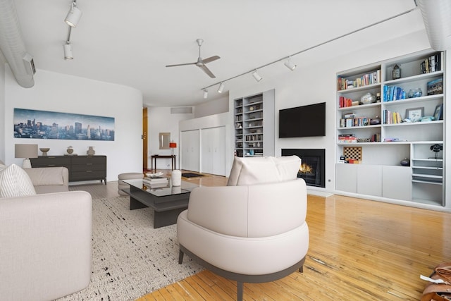 957 W Huron St Unit 2, Chicago, IL 60642 - living room featuring track lighting, hardwood / wood-style floors, a ceiling fan, a glass covered fireplace, and built in features