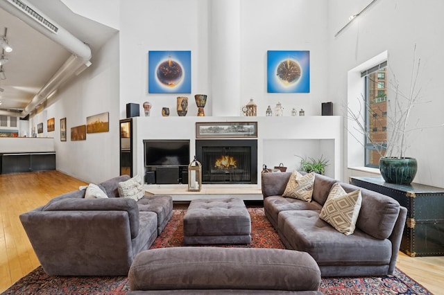 957 W Huron St Unit 2, Chicago, IL 60642 - living room featuring wood finished floors, a lit fireplace, and a high ceiling