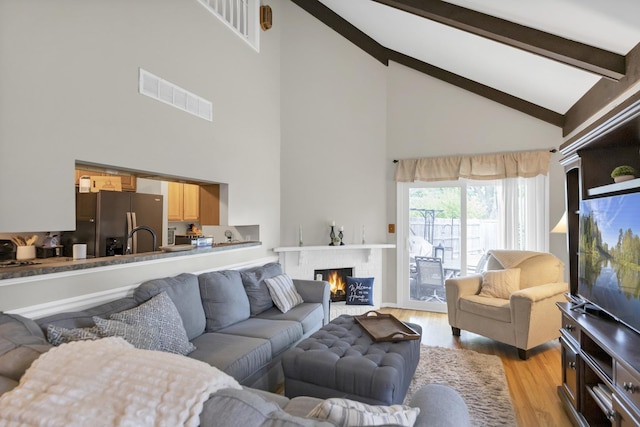 93 Faringdon Dr, Crystal Lake, IL 60014 - living room featuring high vaulted ceiling, light wood-style flooring, beam ceiling, and a fireplace