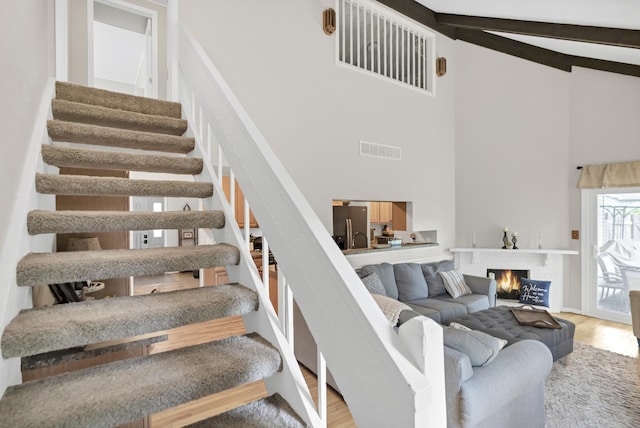 93 Faringdon Dr, Crystal Lake, IL 60014 - staircase featuring high vaulted ceiling, wood finished floors, beam ceiling, and a fireplace