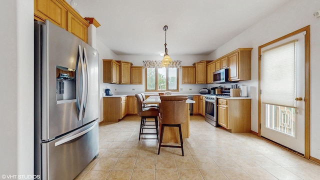11 Carrington Ct, Hazel Crest, IL 60429 - kitchen with appliances with stainless steel finishes, light countertops, a center island, and a breakfast bar