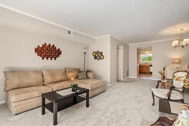 3256 Sanders Rd Unit 4E, Northbrook, IL 60062 - living area with carpet, a chandelier, and ornamental molding