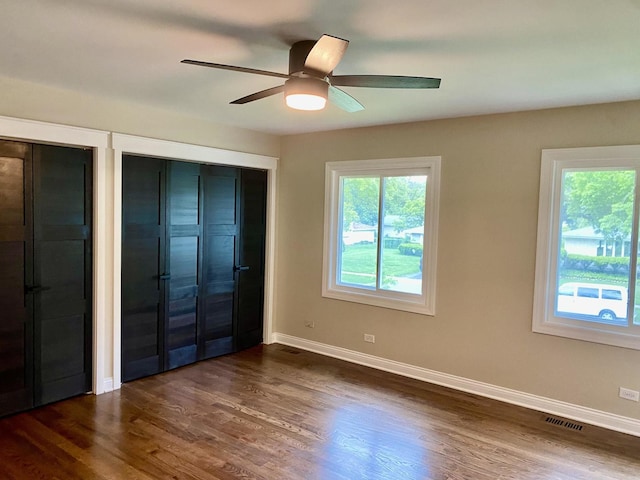 824 62nd St, Downers Grove, IL 60516 - unfurnished bedroom with two closets, dark wood-style floors, and a ceiling fan