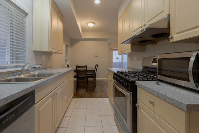 719 W 31st St Unit 2, Chicago, IL 60616 - kitchen with appliances with stainless steel finishes, under cabinet range hood, backsplash, light tile patterned floors, and light countertops