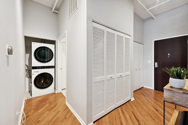 950 W Monroe St Unit 808, Chicago, IL 60607 - laundry area with stacked washing machine and dryer, light wood-style floors, and a towering ceiling