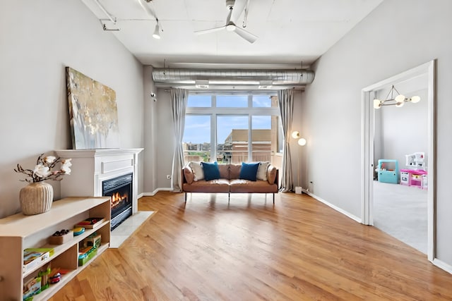 950 W Monroe St Unit 808, Chicago, IL 60607 - living area featuring a ceiling fan, a fireplace with flush hearth, wood finished floors, and rail lighting