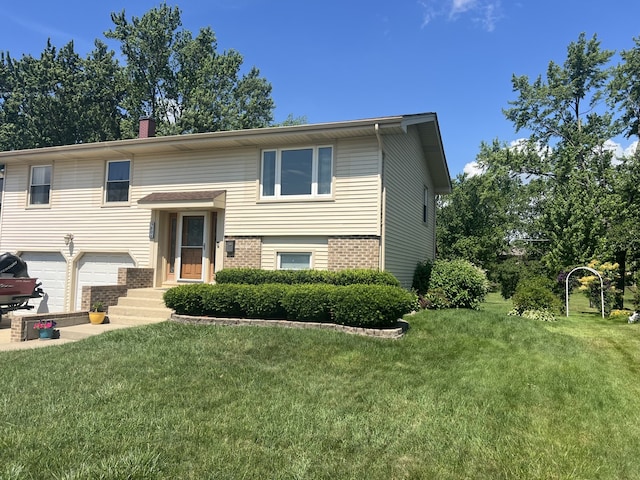 980 Hillcrest Blvd, Hoffman Estates, IL 60169 - split foyer home featuring brick siding, a front yard, an attached garage, and a chimney
