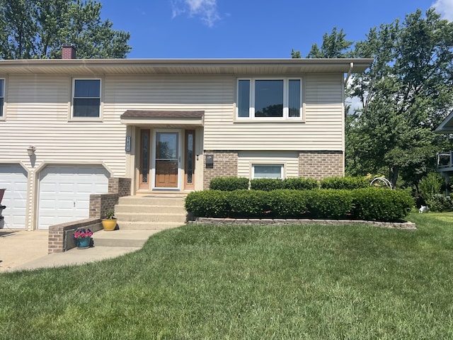 980 Hillcrest Blvd, Hoffman Estates, IL 60169 - split foyer home featuring brick siding, a front yard, an attached garage, a chimney, and entry steps
