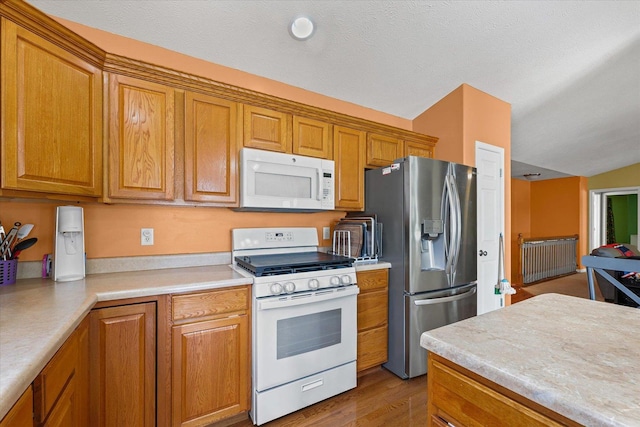 402 Wesley Ave, Savoy, IL 61874 - kitchen with white appliances, brown cabinetry, light countertops, and wood finished floors