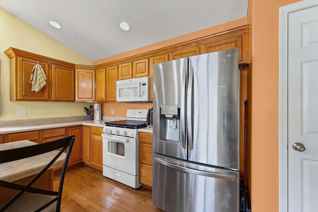 402 Wesley Ave, Savoy, IL 61874 - kitchen with white appliances, lofted ceiling, light countertops, wood finished floors, and brown cabinets