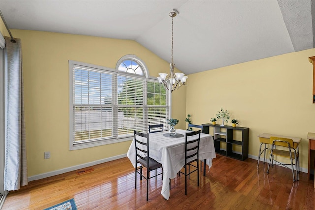 402 Wesley Ave, Savoy, IL 61874 - dining space with a chandelier, vaulted ceiling, and wood finished floors