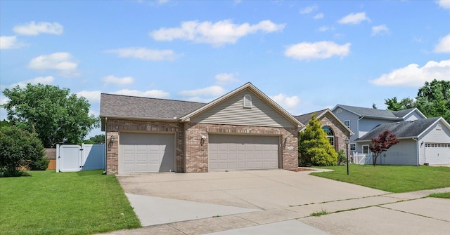 402 Wesley Ave, Savoy, IL 61874 - view of front of house with brick siding, a gate, driveway, and an attached garage