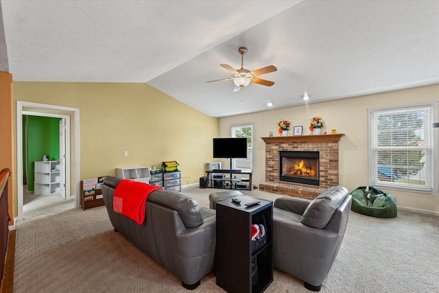 402 Wesley Ave, Savoy, IL 61874 - living room with light colored carpet, lofted ceiling, ceiling fan, a fireplace, and a textured ceiling
