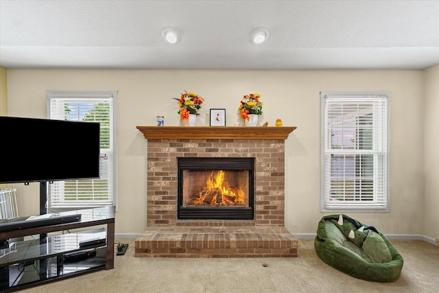402 Wesley Ave, Savoy, IL 61874 - carpeted living room featuring a fireplace and baseboards