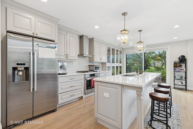 3118 River Falls Dr, Northbrook, IL 60062 - kitchen featuring appliances with stainless steel finishes, wall chimney exhaust hood, light wood-style floors, backsplash, and a chandelier